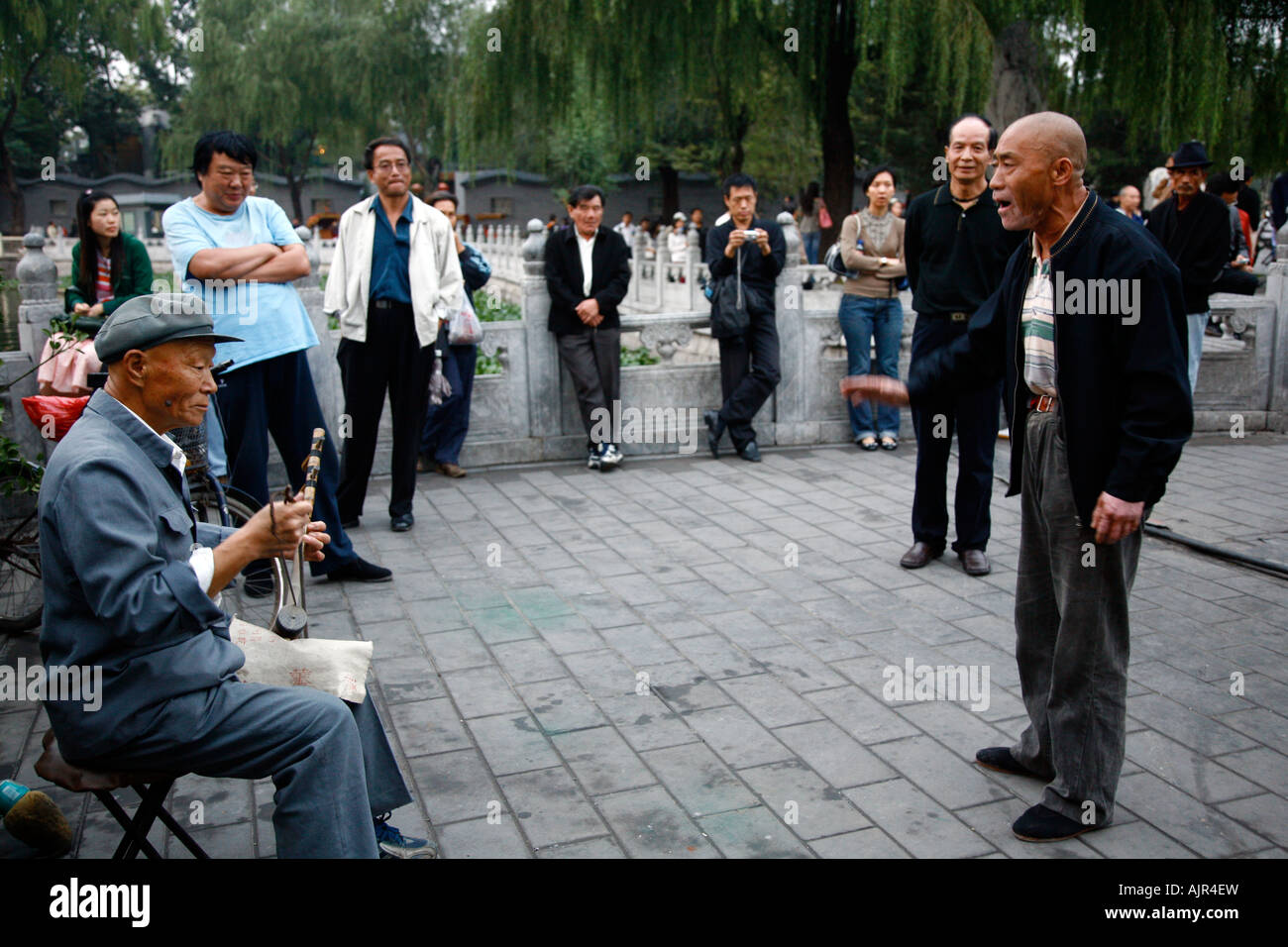 Singer and a musician playing an instrument called erhu at the Houhai lake area Beijing China Stock Photo