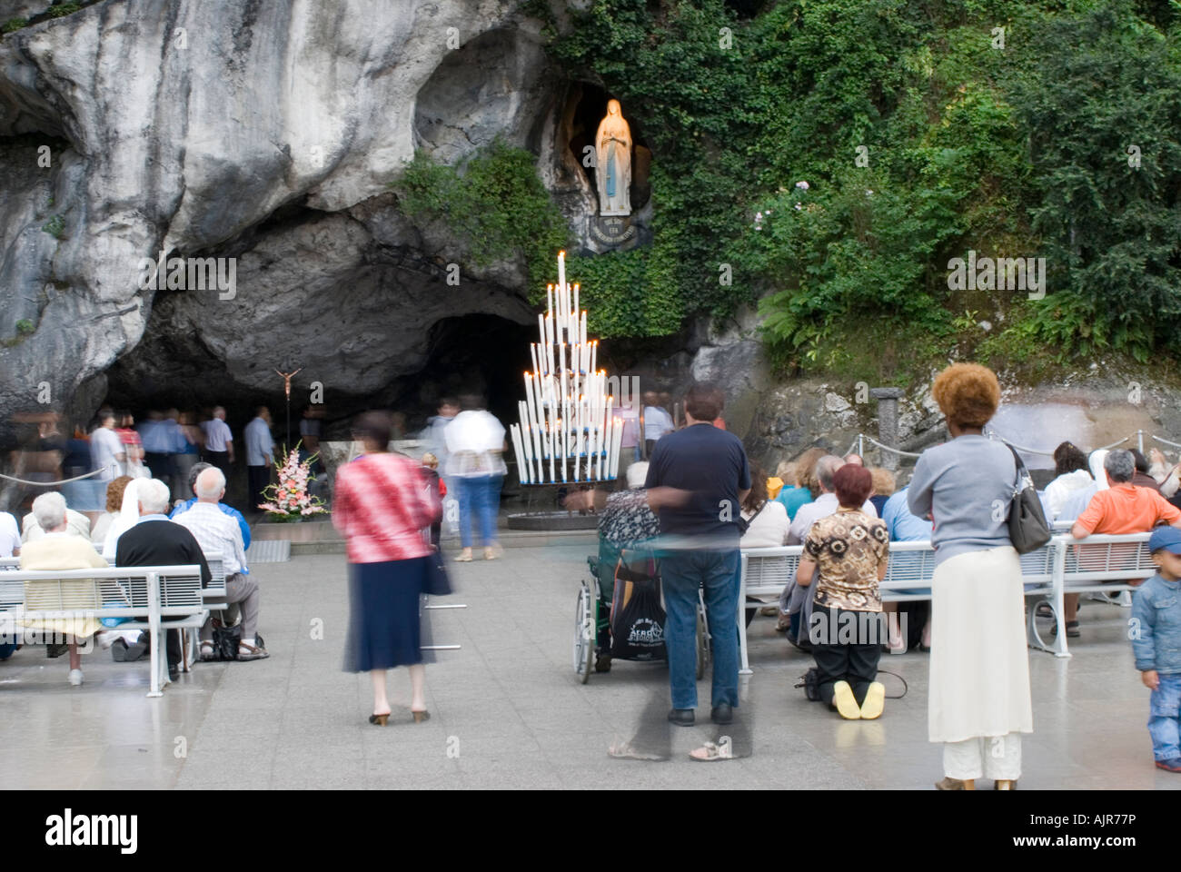 Pilgrims with wheelchair in front Grotto, NotreDame of Lourdes Stock