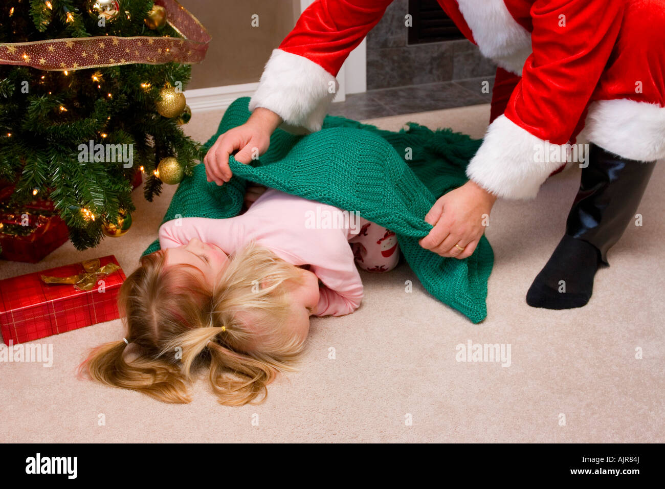 Santa Putting A Blanket Over Two Sleeping Kids Stock Photo Alamy