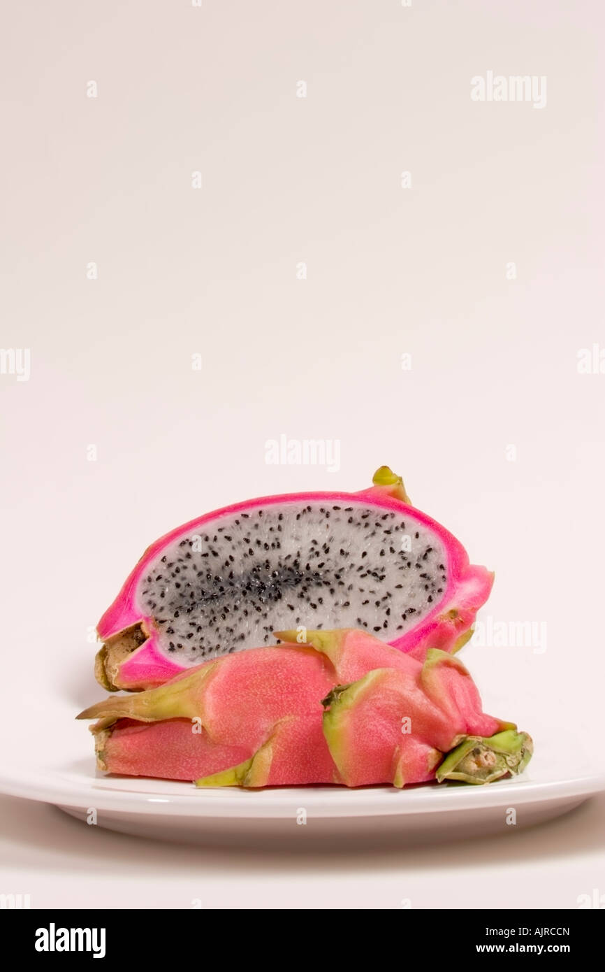Ripe dragon fruit, hylocereus undatus, cut in half to show the white flesh and seeds Stock Photo