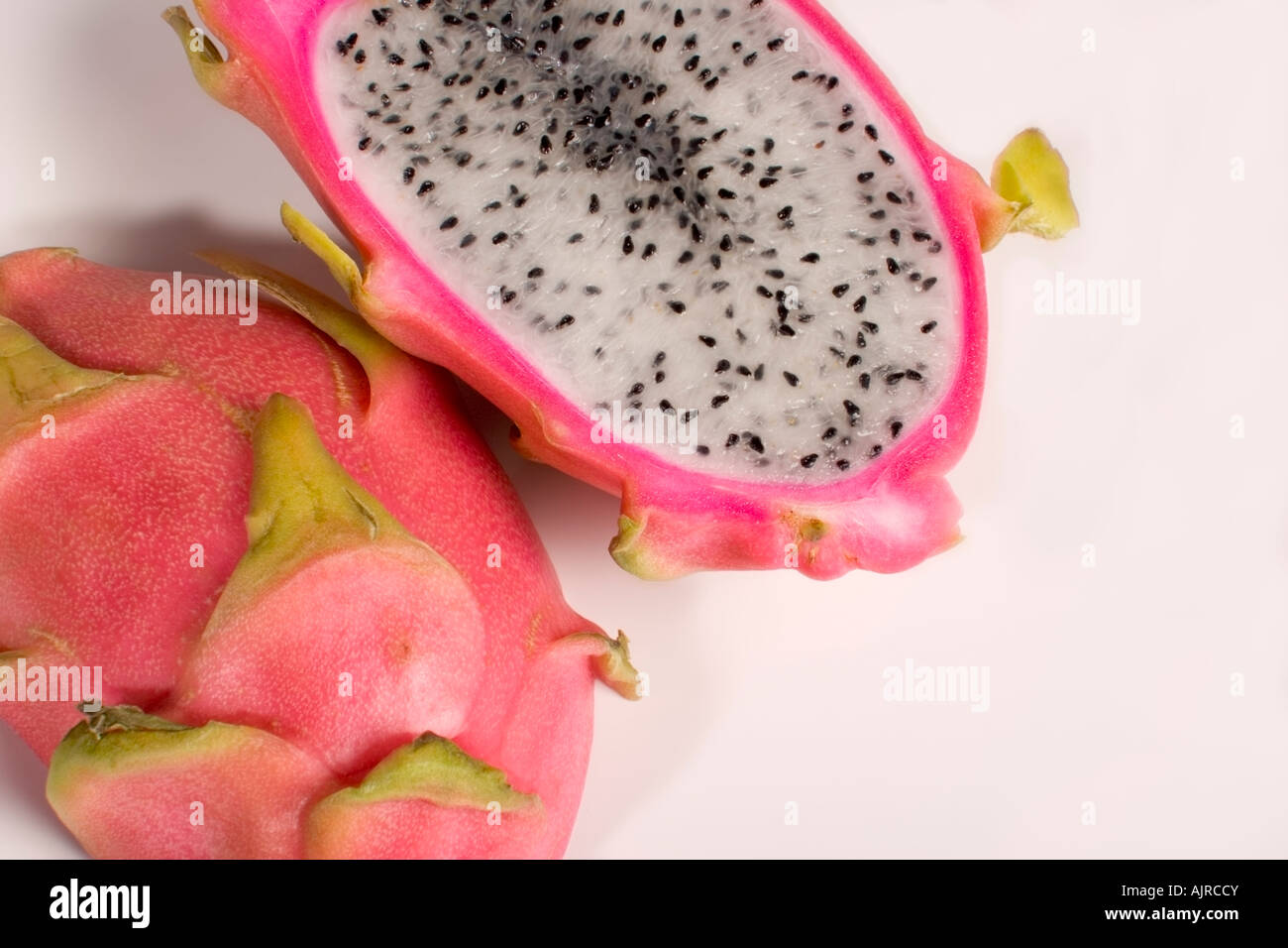 Ripe dragon fruit, hylocereus undatus, cut in half to show the white flesh and seeds Stock Photo