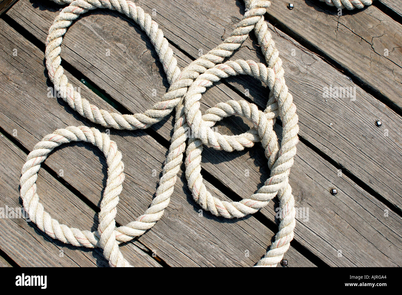 rope twine string braid braided rope twisted loose laying on the ground  deck dock wood lumber boat rope circles curves laying ar Stock Photo - Alamy