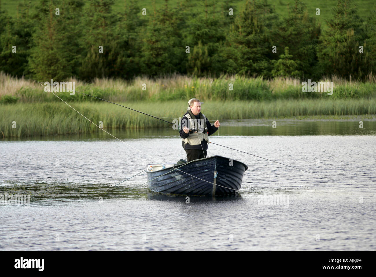 Fly fishing for lake trout from a boat Tildarg fishery county antrim northern ireland Stock Photo