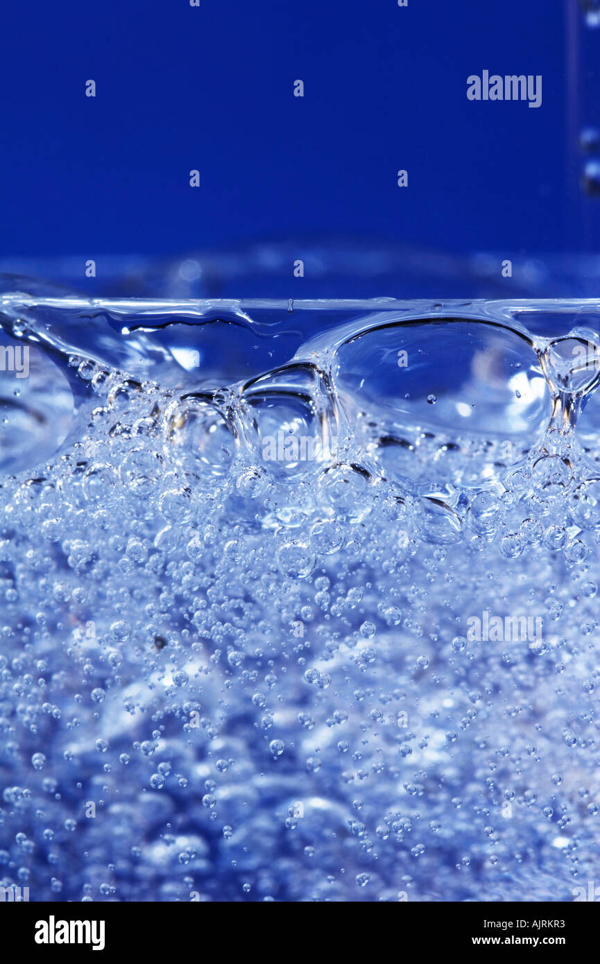 Glass sparkling water on blue background Stock Photo - Alamy