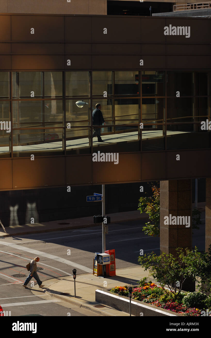 Pedestrians crossing a skywalk bridge over Grand Ave in Des Moines Iowa