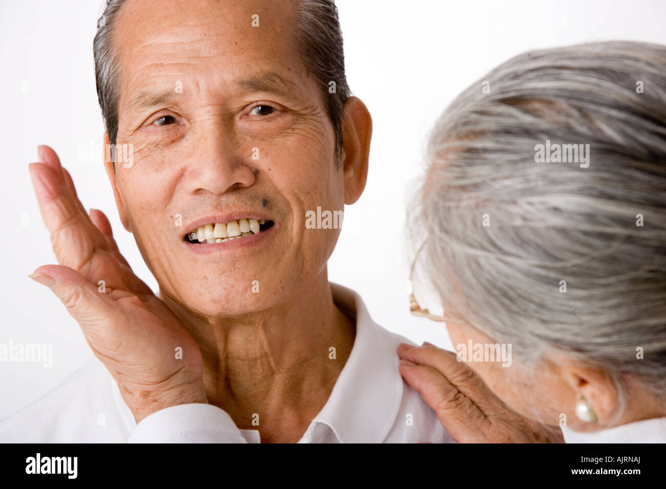 Close-up of a senior woman holding a senior man's face in her hands Stock Photo