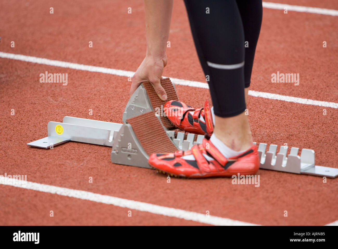 Athlete setting his starting block Stock Photo - Alamy