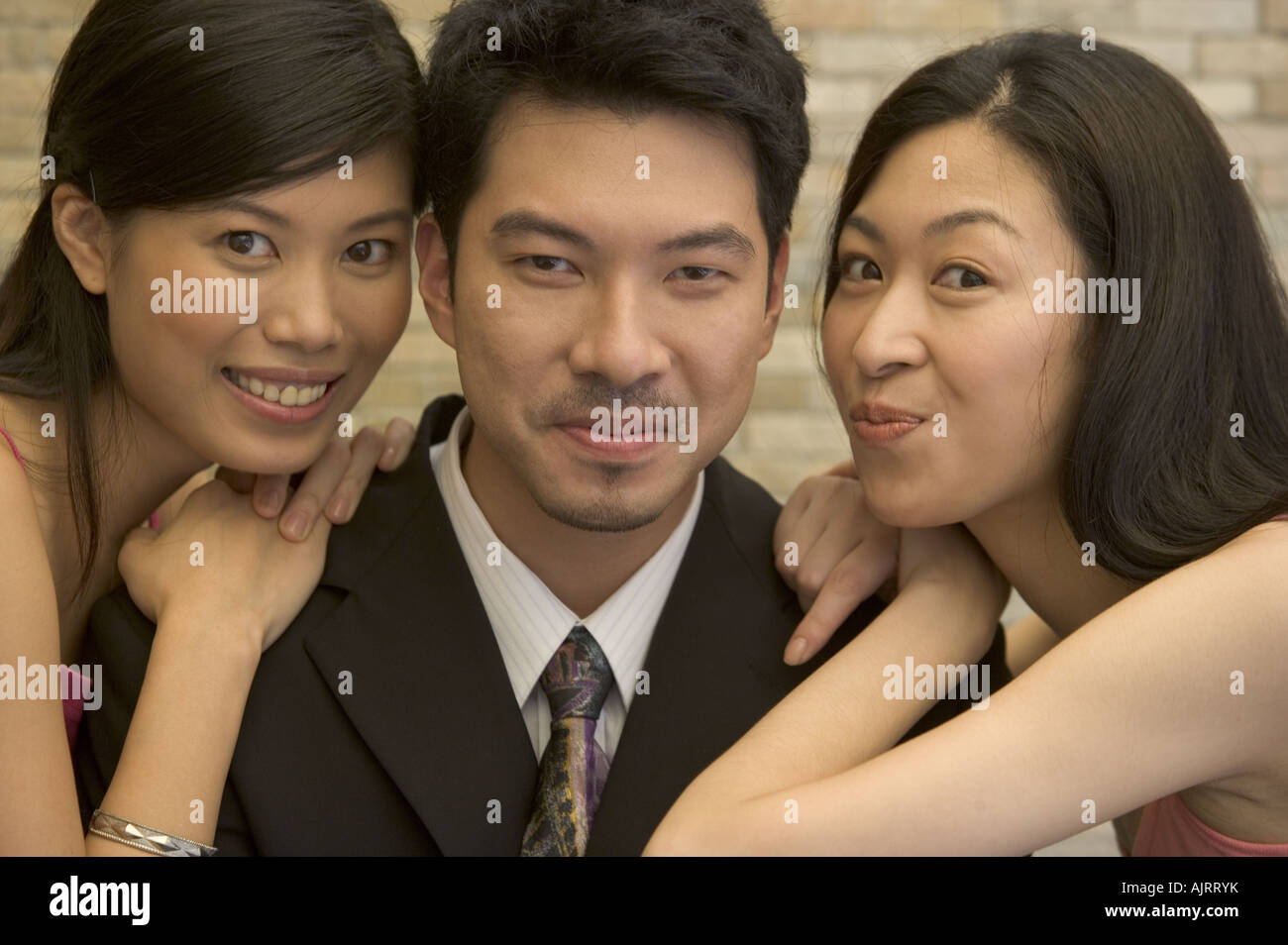 Portrait of a young man and two young women smiling Stock Photo