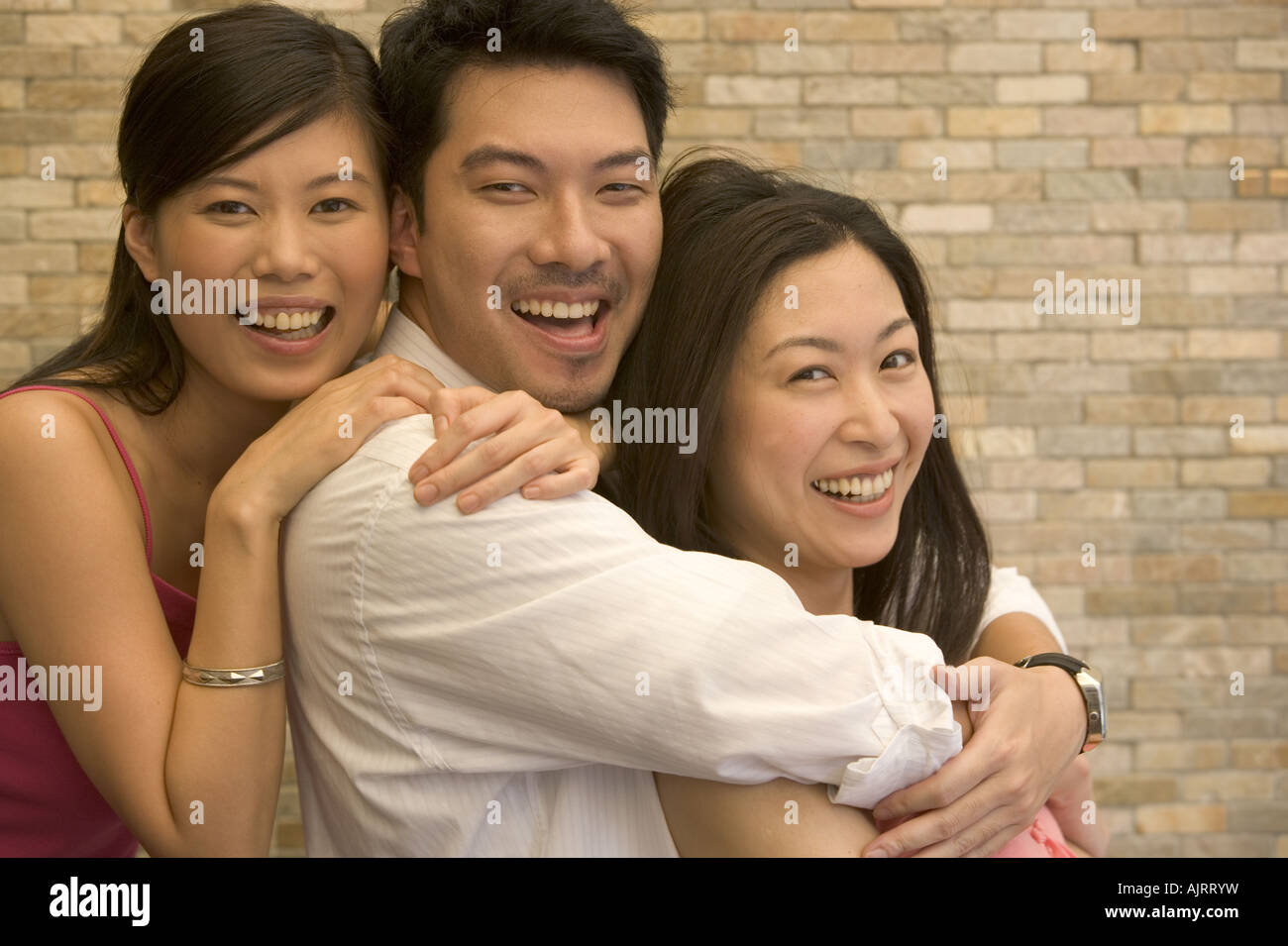 Portrait of a young man and two young women smiling Stock Photo - Alamy
