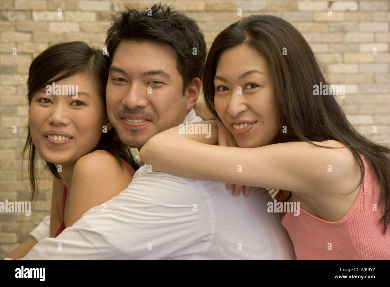 Portrait of a young man and two young women smiling Stock Photo - Alamy
