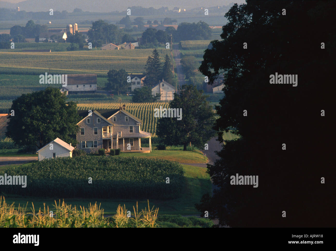 Country road running through dairy farms along rolling hills of Lancaster County Pennsylvania USA Stock Photo