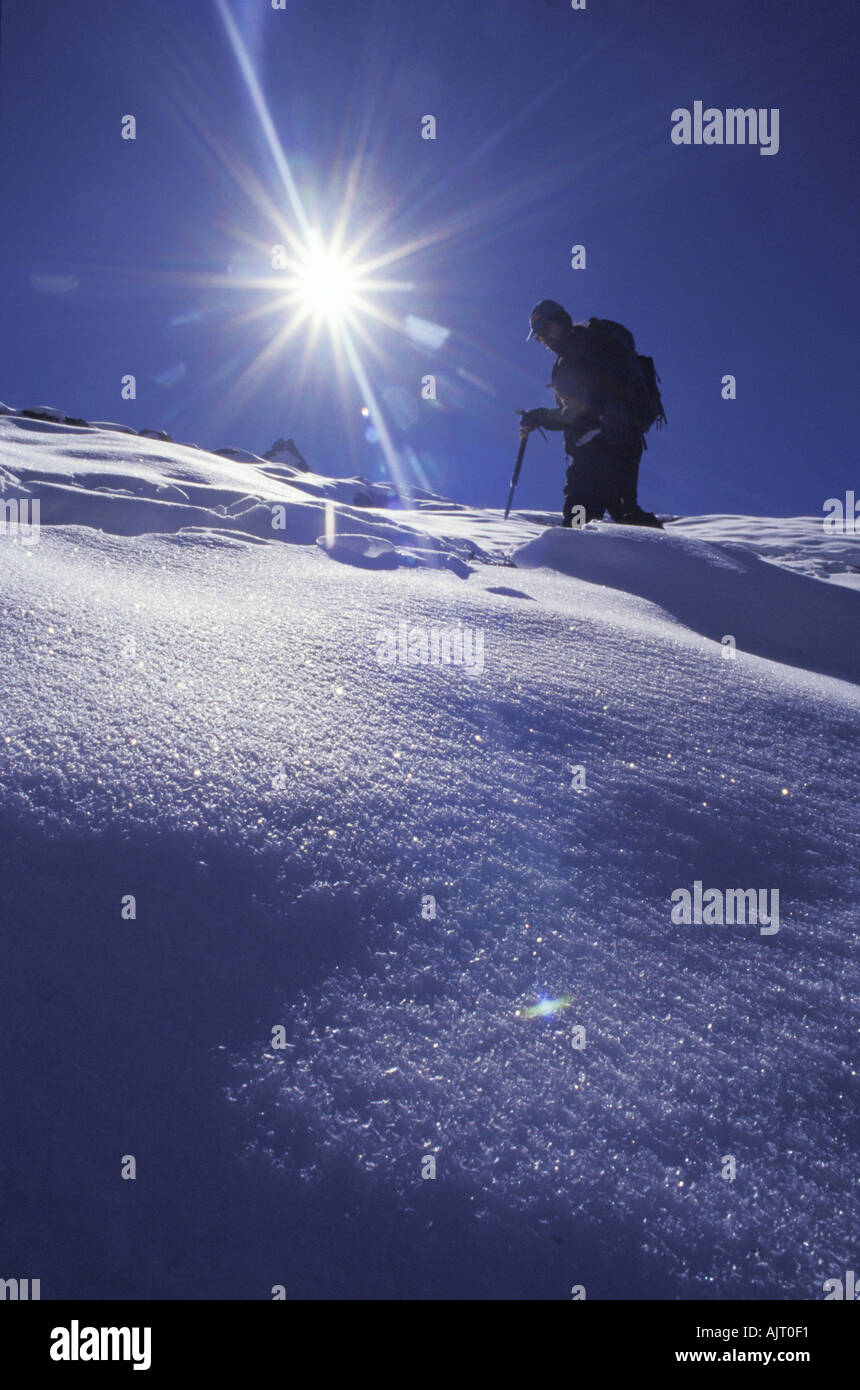 Lone mountaineer walking on snow Stock Photo