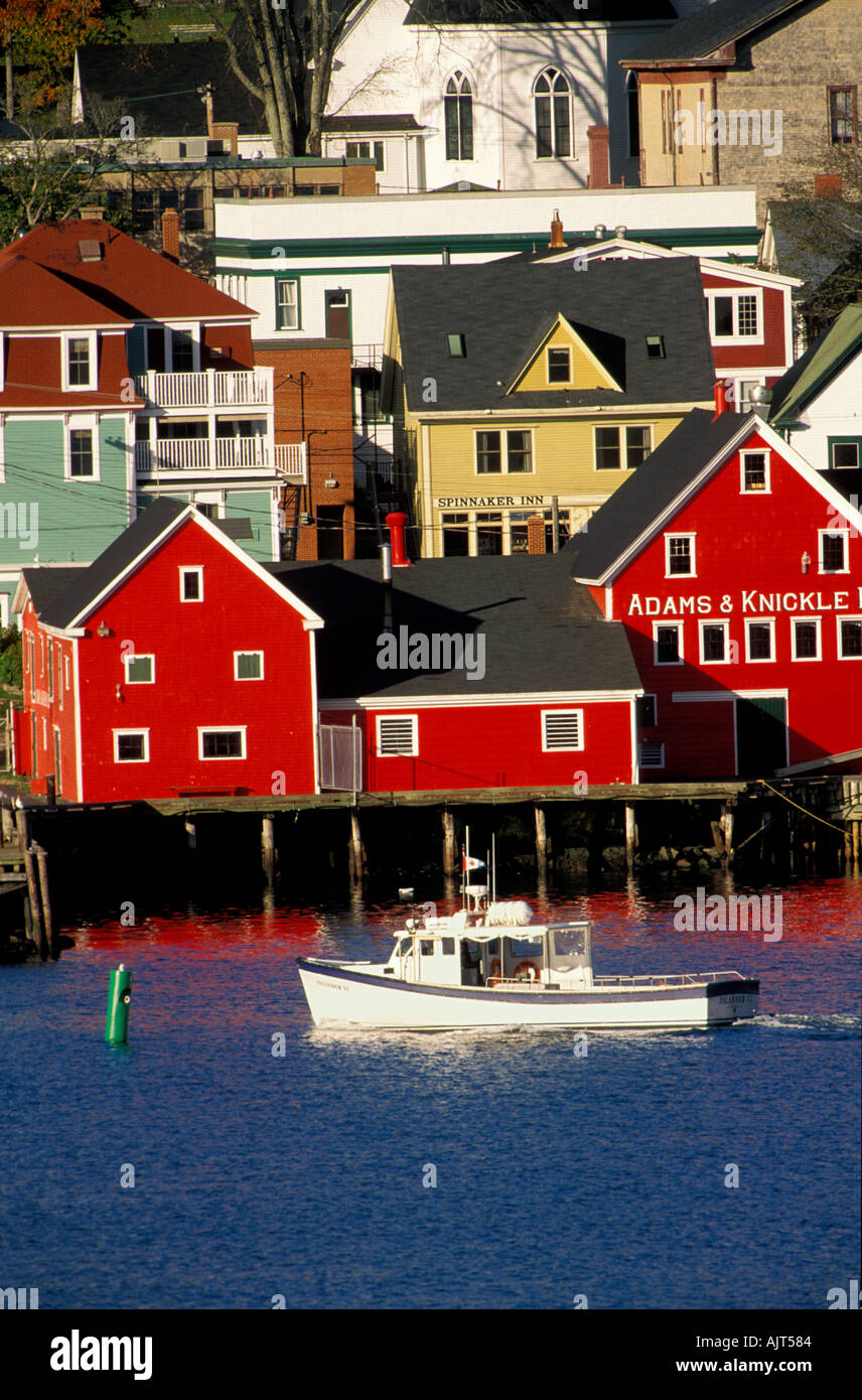 Scenic view of Lunenburg with fishing boat motoring along waterfront and colorful buildings. Nova Scotia, Canada Stock Photo