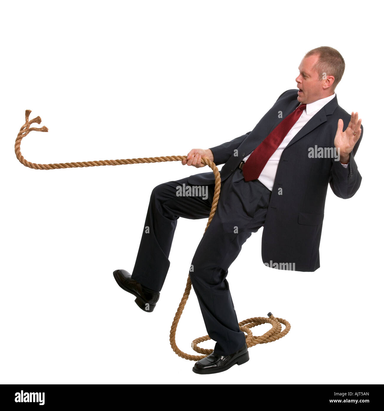 Businessman falling as the rope he was pulling breaks Stock Photo