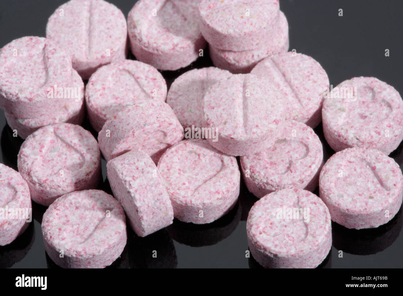 Pink coloured Ecstasy tablet illegal drugs Pills Stock Photo