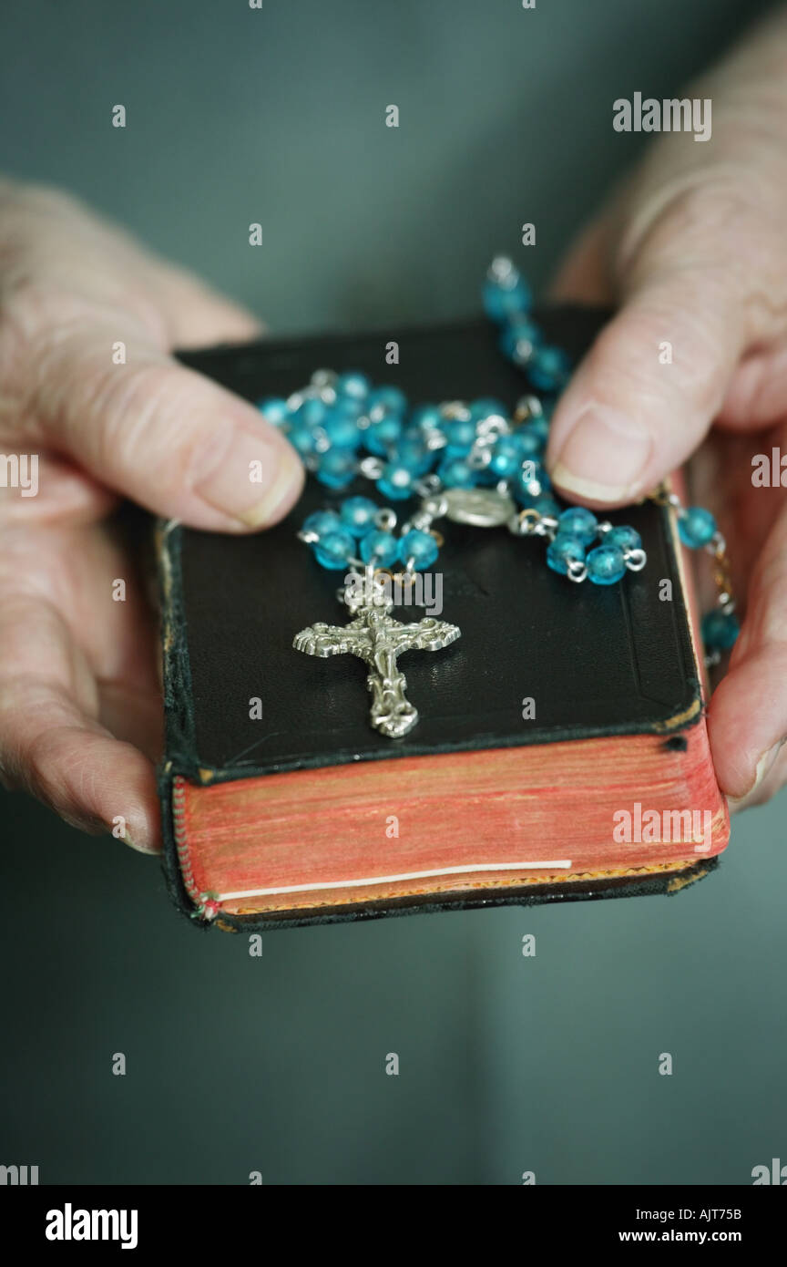 Rosary beads bible held Stock Photo Alamy