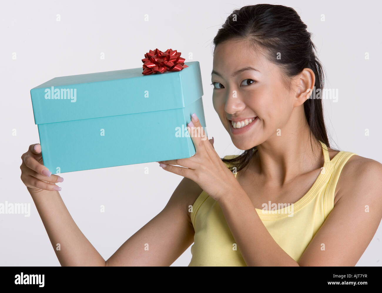 Portrait of a young woman holding a gift box Stock Photo - Alamy