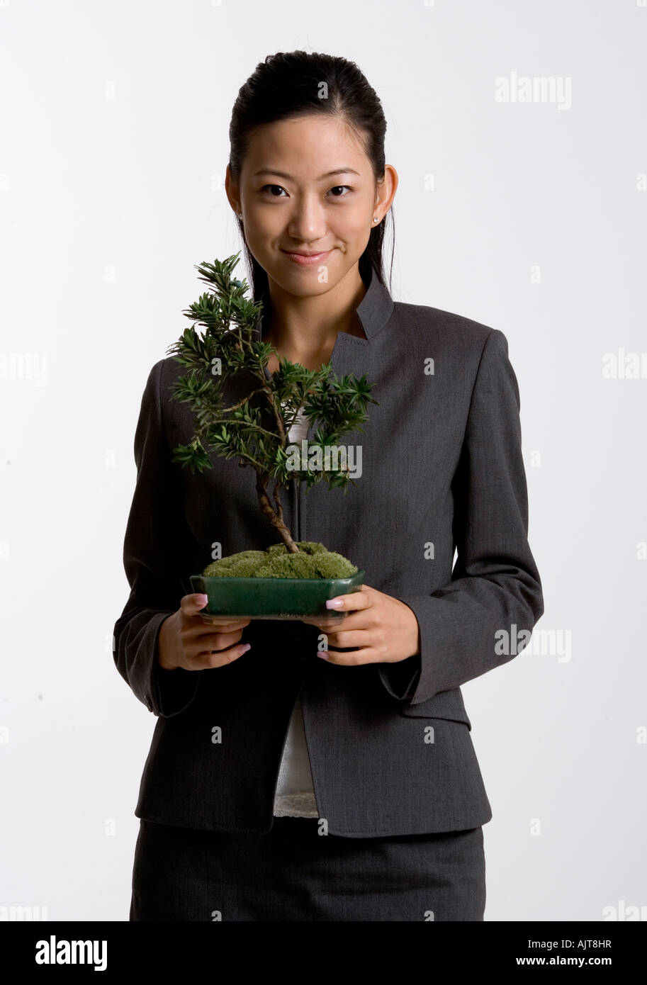Portrait of a young woman holding a potted plant Stock Photo - Alamy