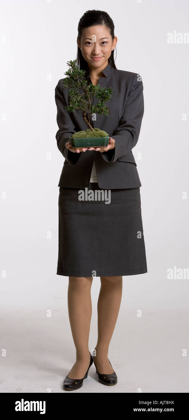 Portrait of a businesswoman holding a potted plant Stock Photo - Alamy