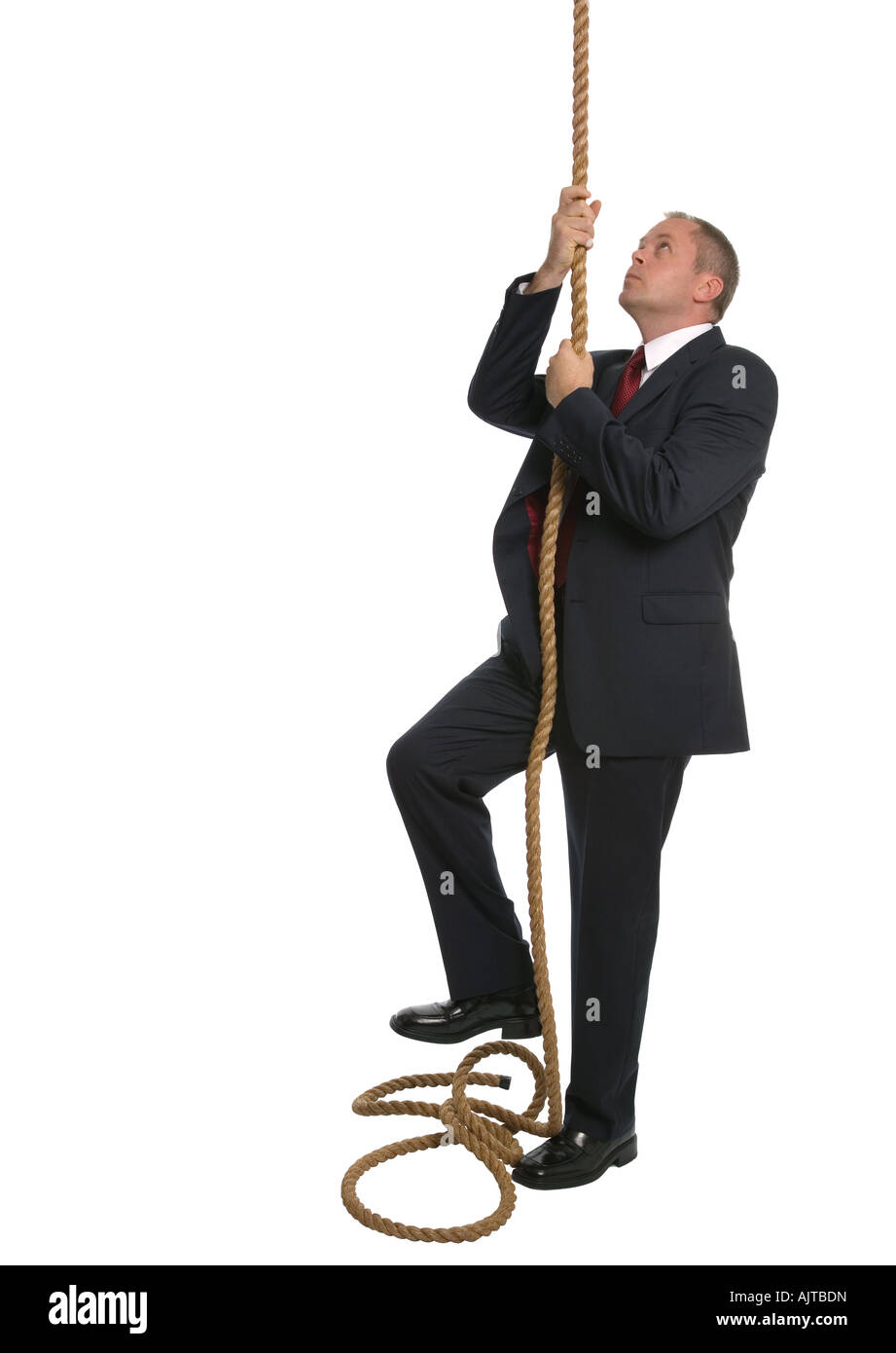 Businessman looking to climb to the top of a rope Stock Photo