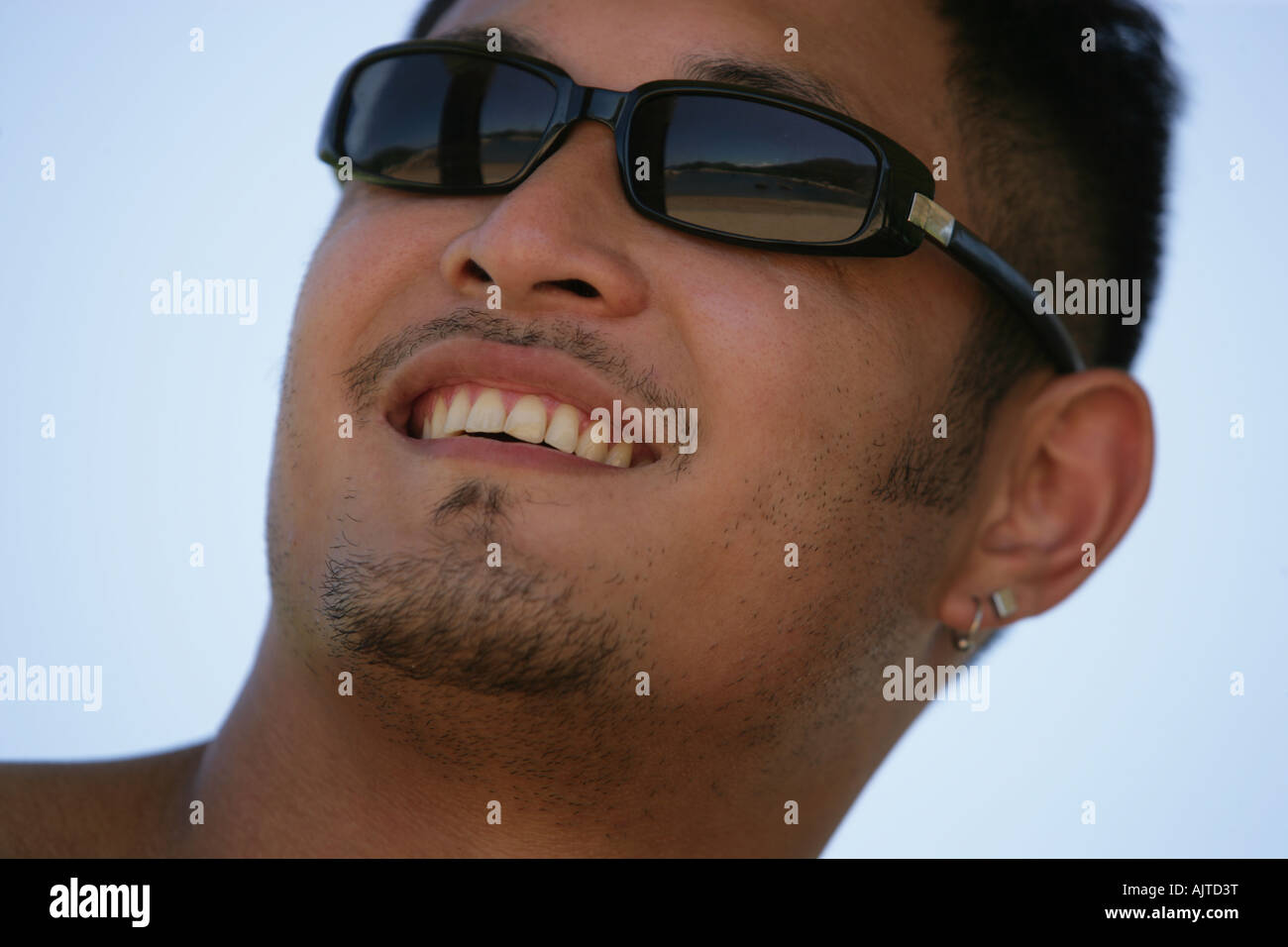 Close-up of a young man wearing sunglasses and smiling Stock Photo - Alamy