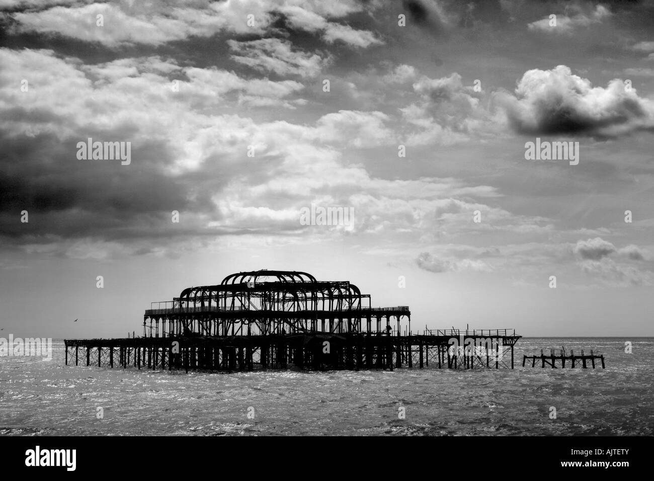 Remains of Brighton Pier left standing in sea with dark clouds, Brighton West Pier, England, UK Stock Photo