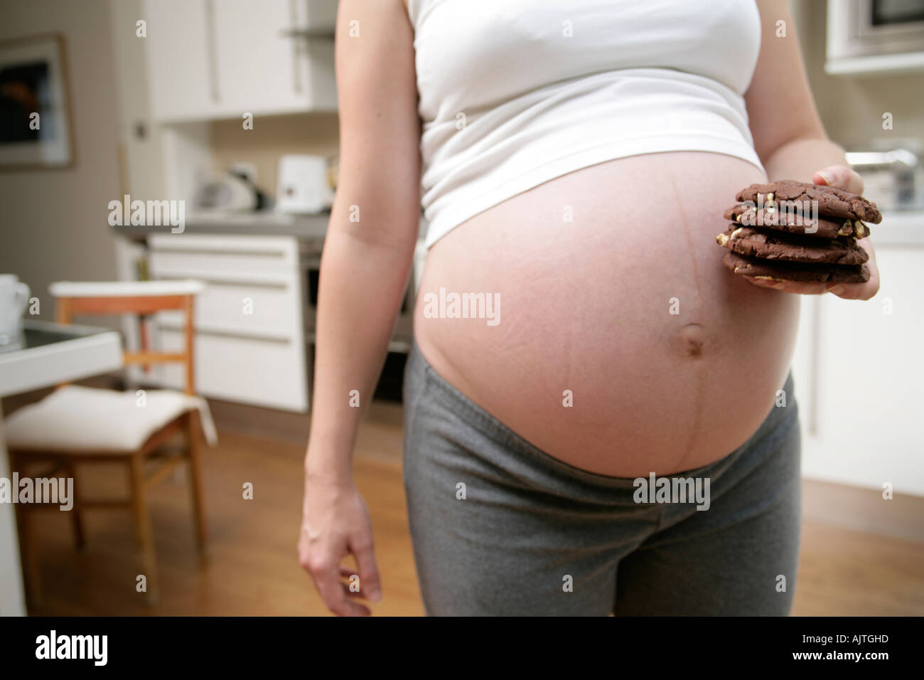 Pregnant woman raiding the cookie jar Stock Photo