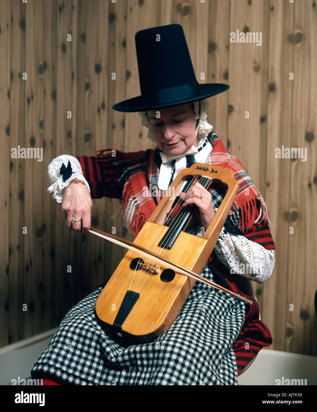 A Crwth an ancient Welsh stringed musical instrument played by a musician in traditional Welsh dress Stock Photo