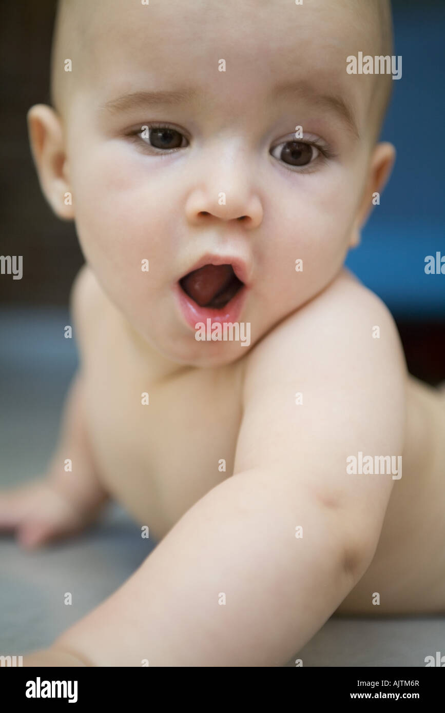Baby lying on floor, mouth wide open Stock Photo