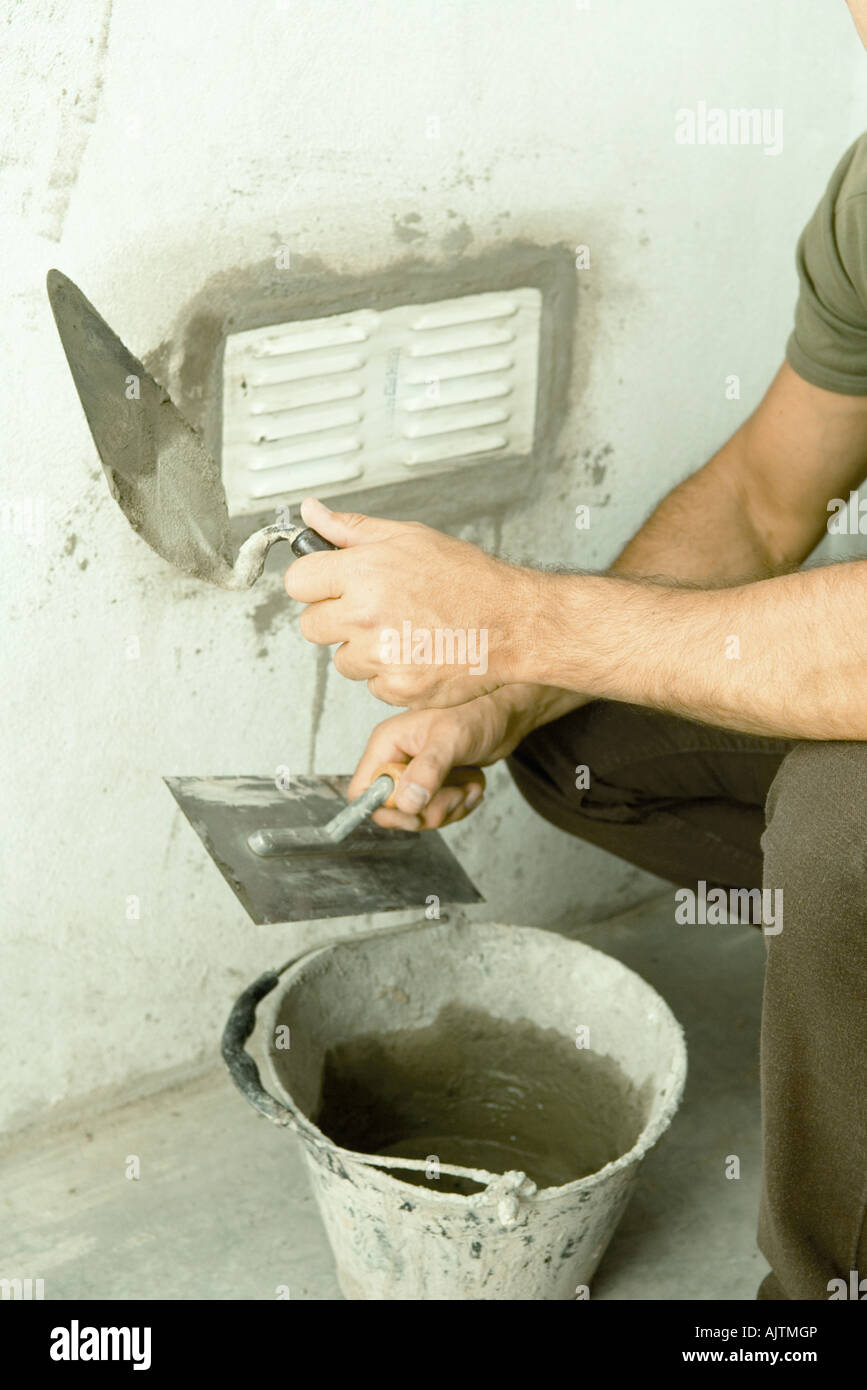 Man applying putty around air vent, cropped view Stock Photo