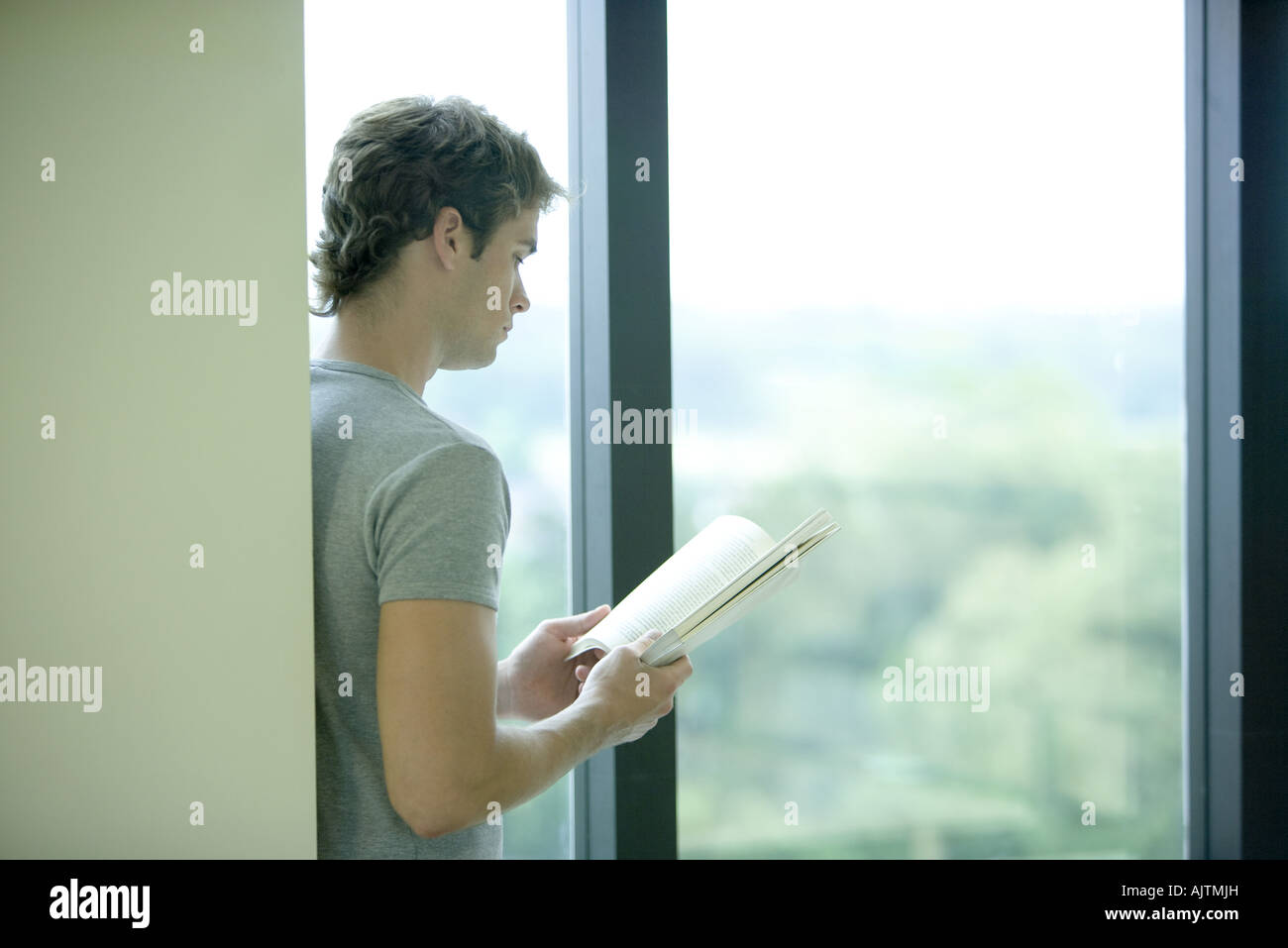 Male college student reading in library Stock Photo