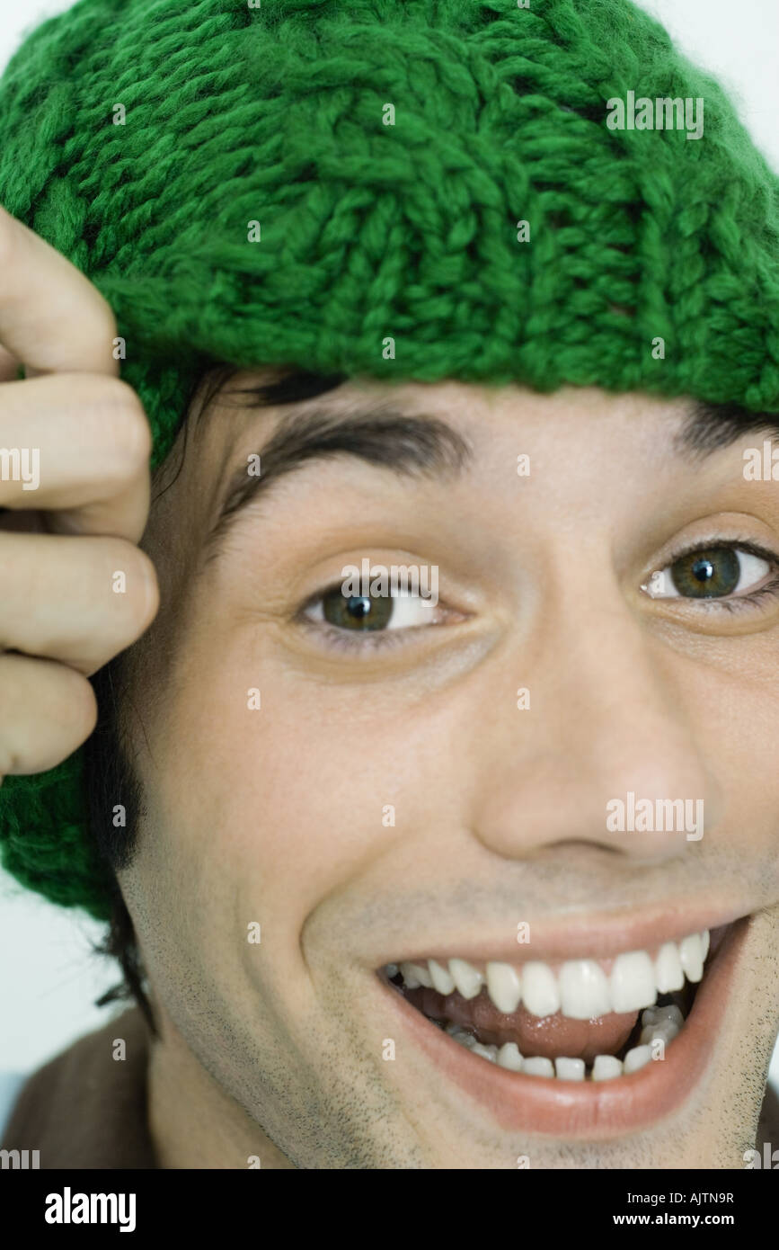 Young man wearing knit hat, smiling at camera, portrait Stock Photo