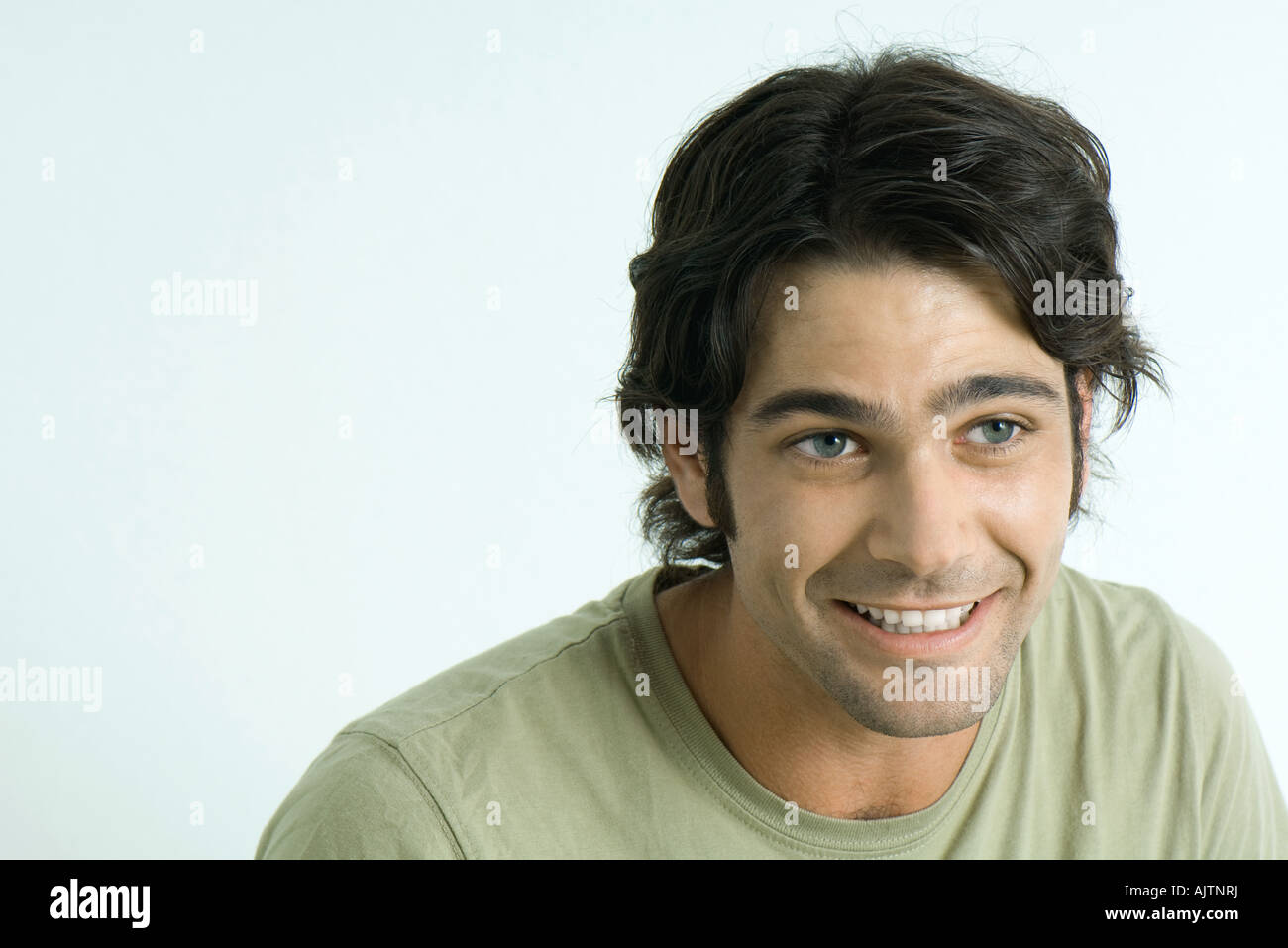 Man smiling, raising eyebrows, looking away Stock Photo