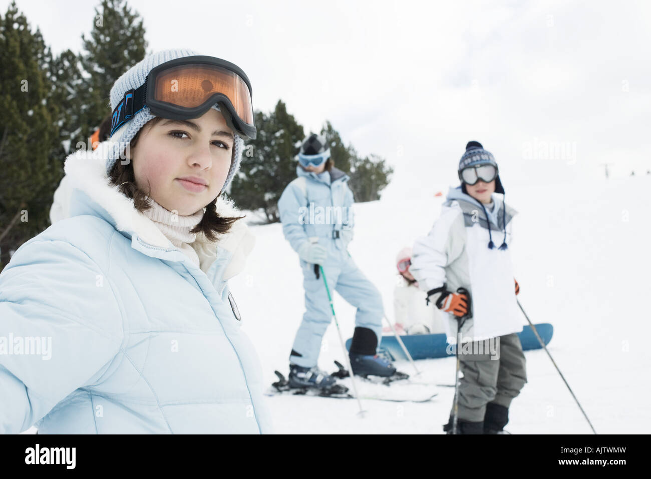 Group of young friends on skis, focus on teen girl in foreground Stock Photo