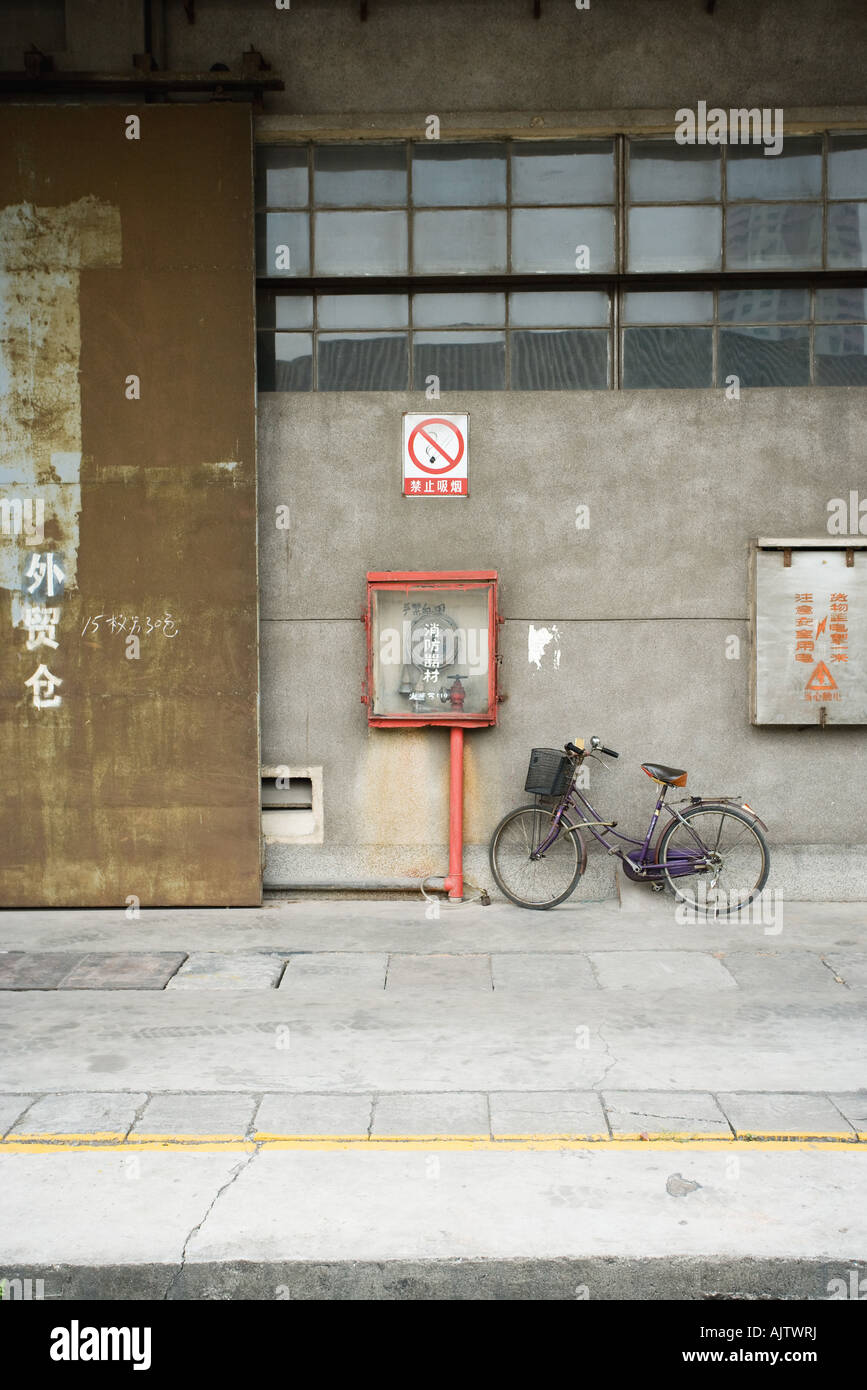 China, Guangdong Province, Guangzhou, bicycle parked against wall Stock Photo