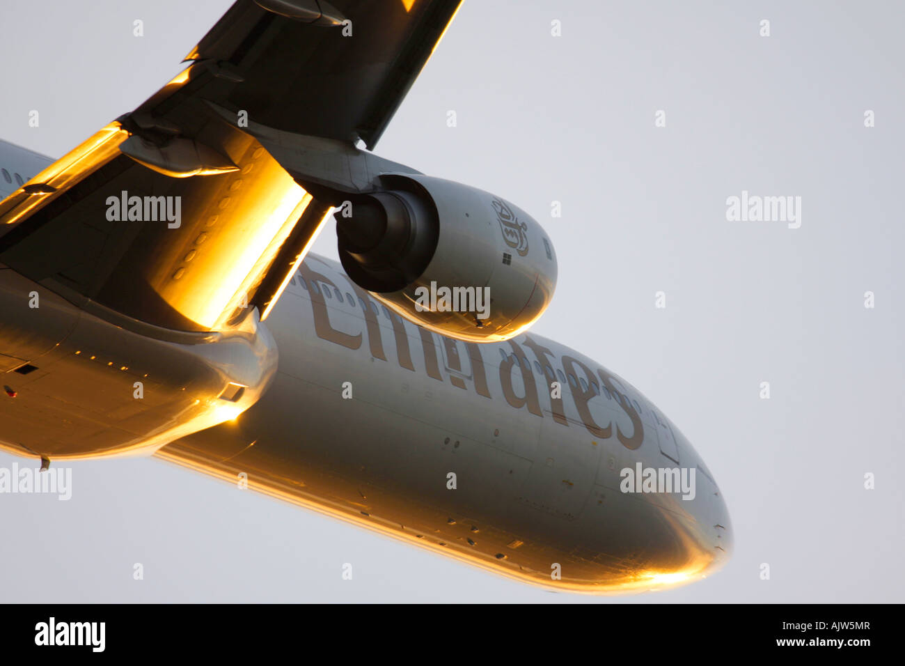 Close-up of Emirates Boeing 777 just after take off in reflecting sunset light at Heathrow Airport, London, England, UK. Stock Photo