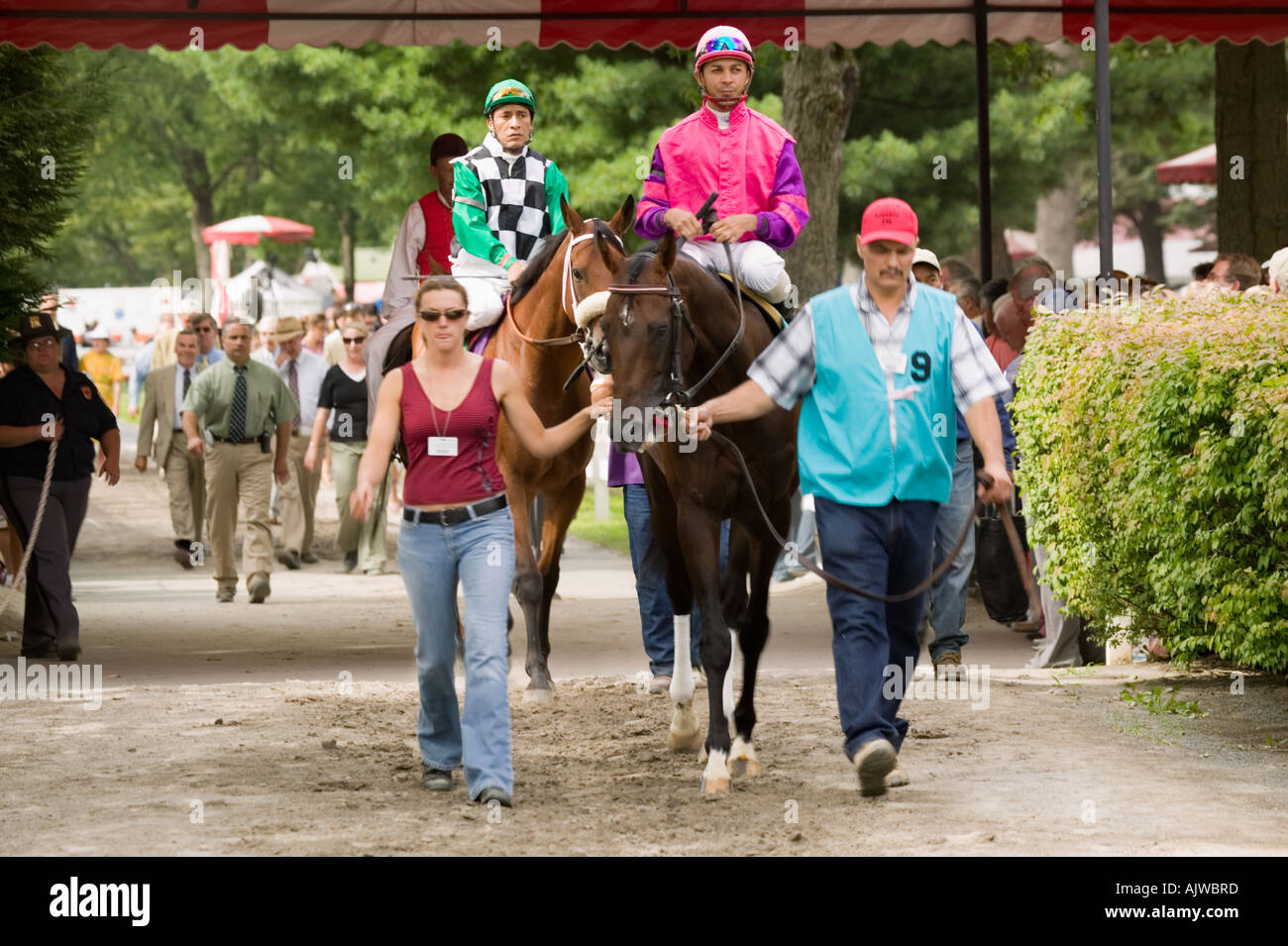 Trainers walking horses and jockeys from paddock to track Saratoga Race