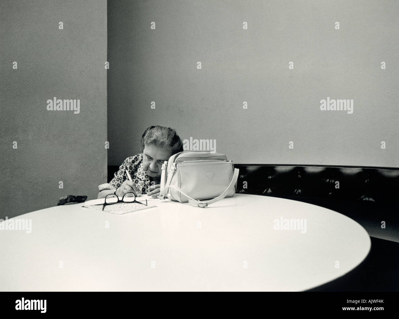 1980s black and white candid of woman (60s) writing letter in Tate Gallery, London. Stock Photo