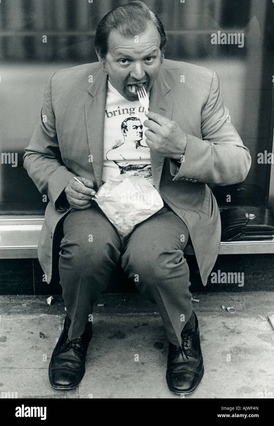 1970s black and white candid of man (50s) eating chips, London. Stock Photo
