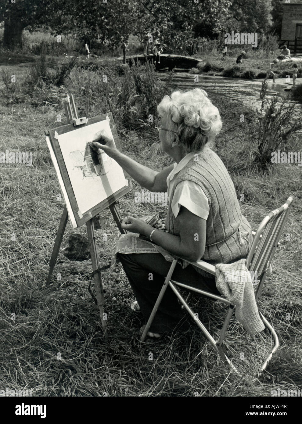 1970s black and white candid of woman (60s) sketching in Cotswolds, UK, 1980s. Stock Photo