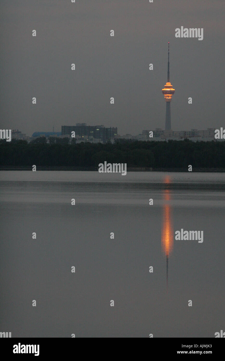 Lights on the China Central TV tower in Beijing reflect in a lake at the summer palace. Stock Photo