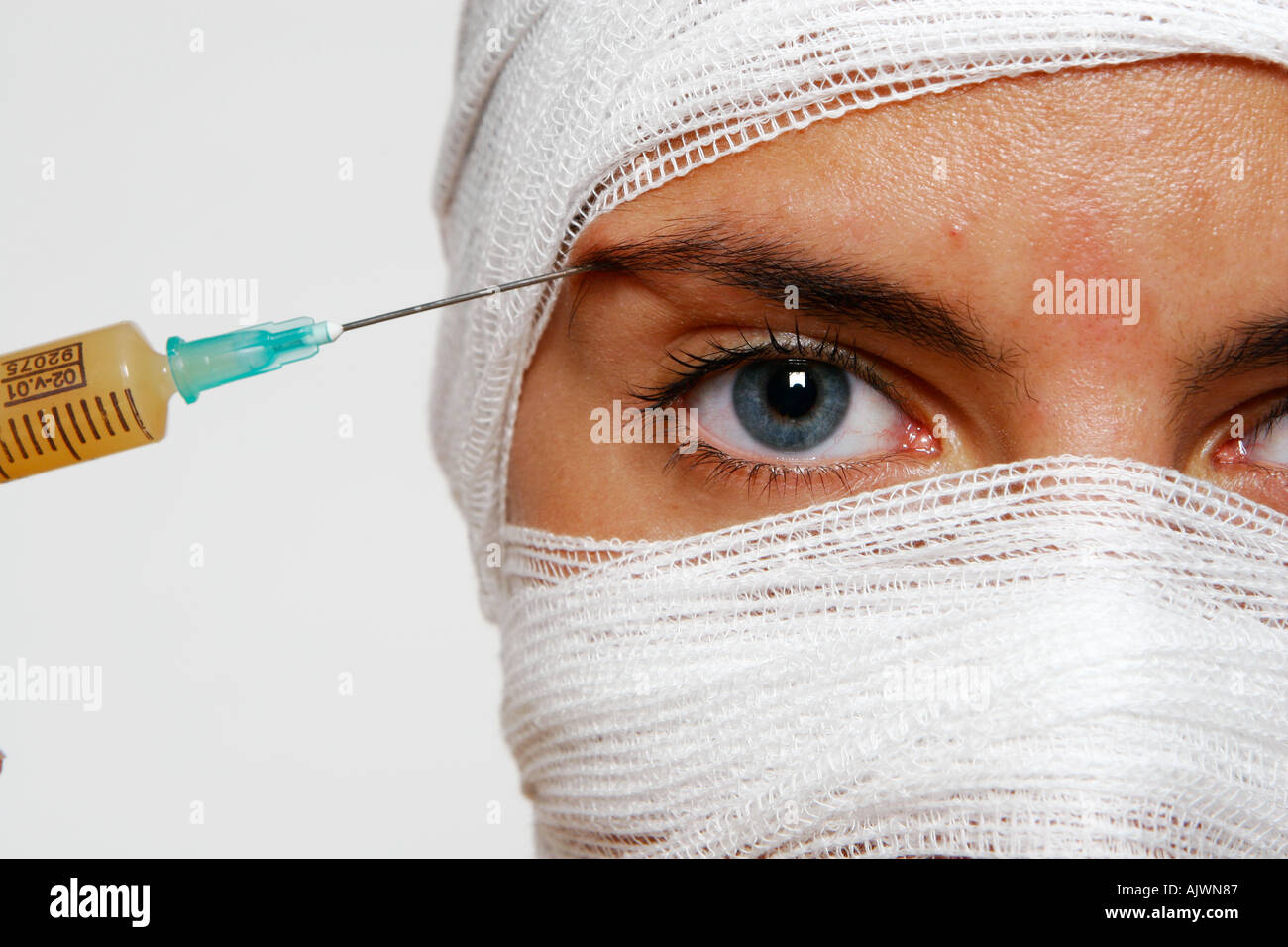 Head shot of woman with a white head dressing and a pink injection ...