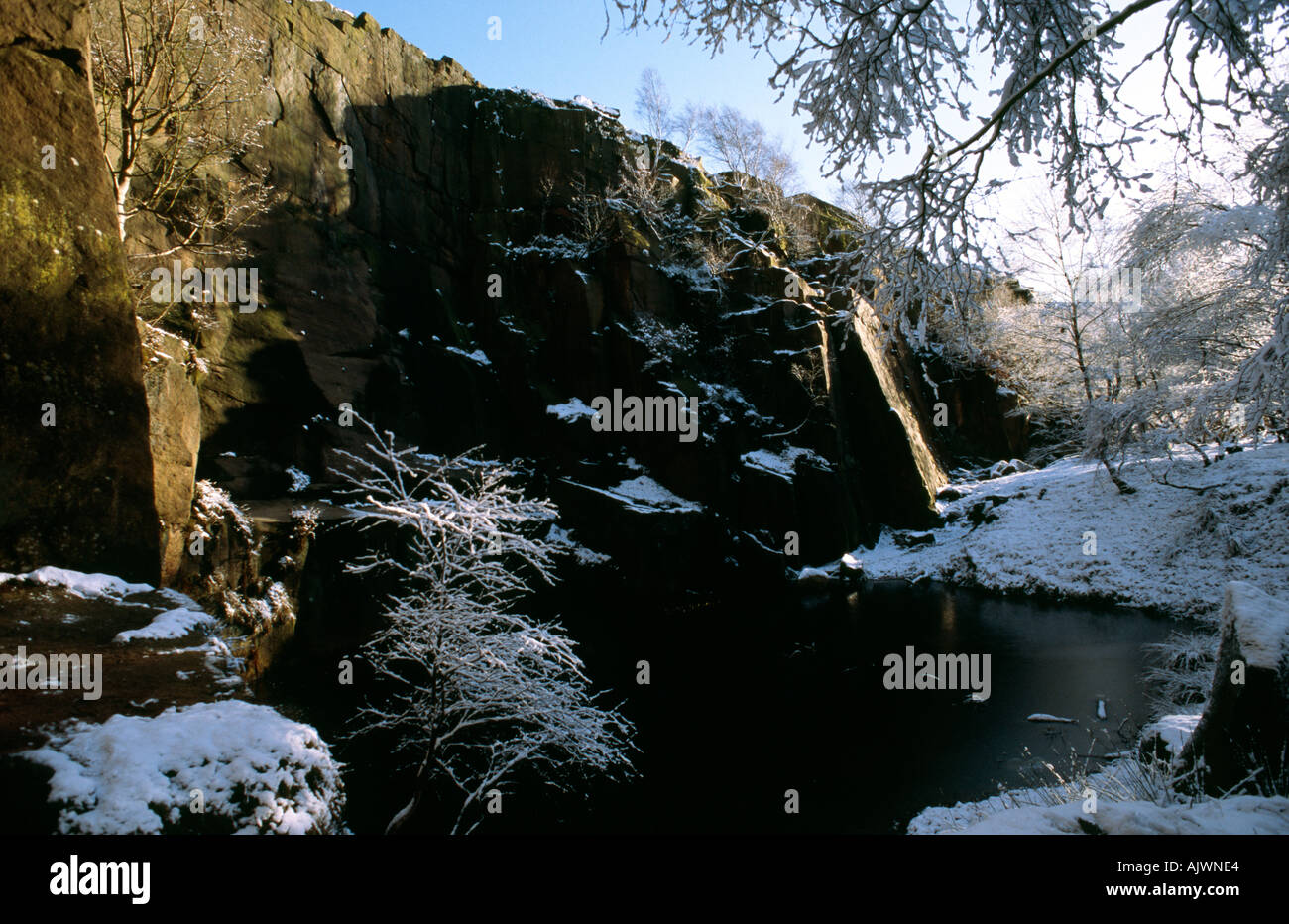 snow and blue sky at climbers crag Lawrencefield quarry Derbyshire Peak District National Park Stock Photo