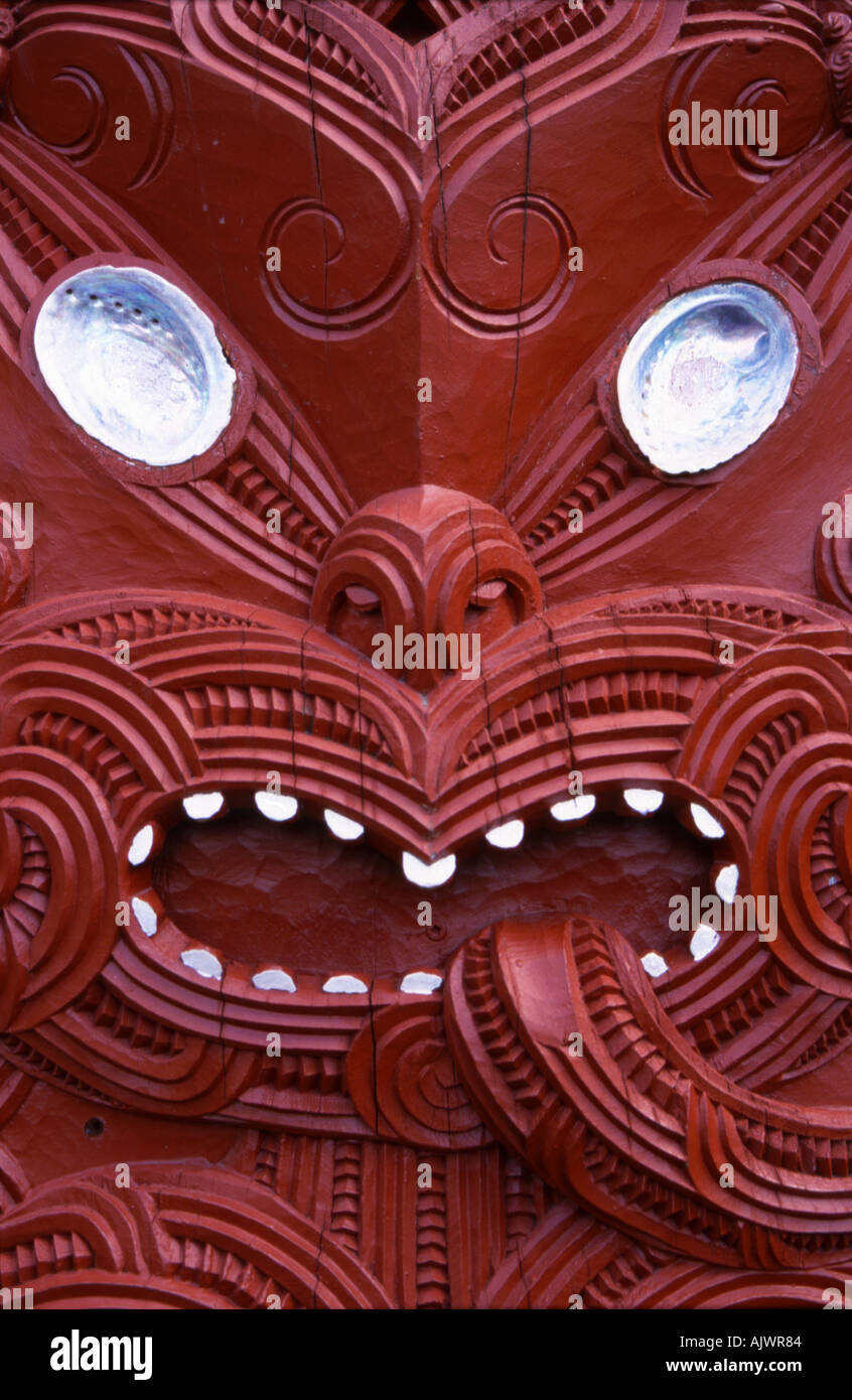 Close up of red carved Maori face tongue exposed in intimidating warrior pose Rotorua New Zealand Stock Photo