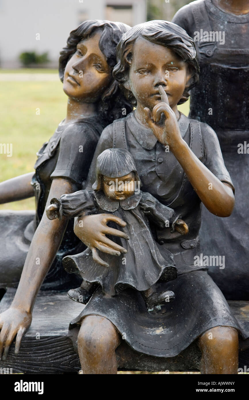 Bronze Statue Of Young Girls Sitting On Bench Together Stock Photo