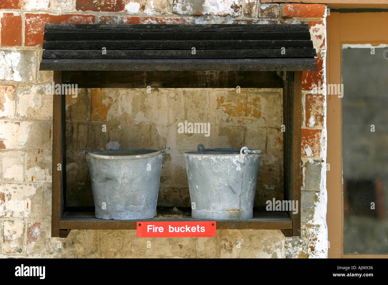 Pair of fire buckets with sign underneath stating Fire Buckets Stock