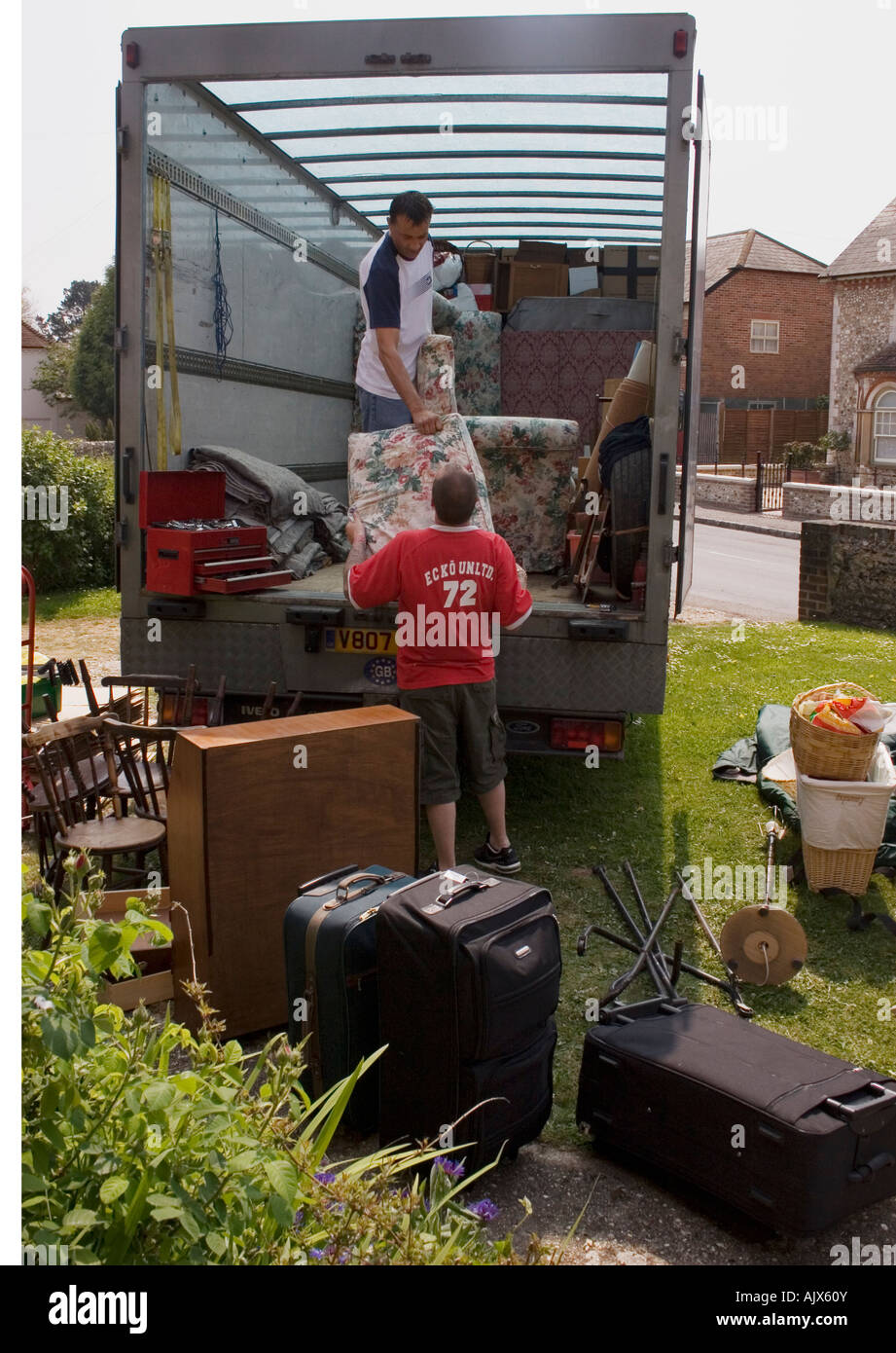 two men loading van with household contents Stock Photo