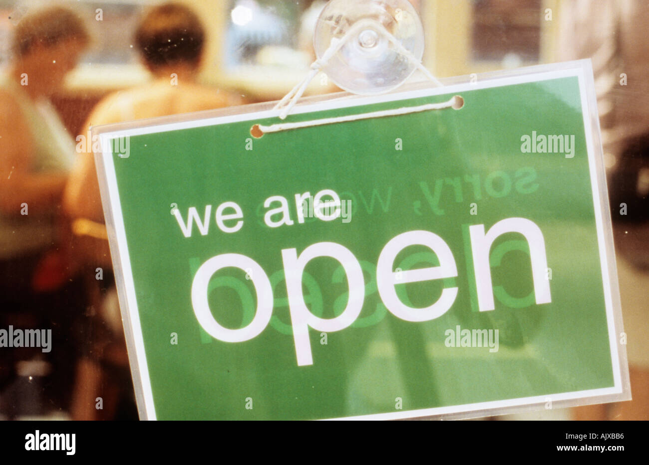 Cafe with diners inside and notice on door saying We are open Stock Photo