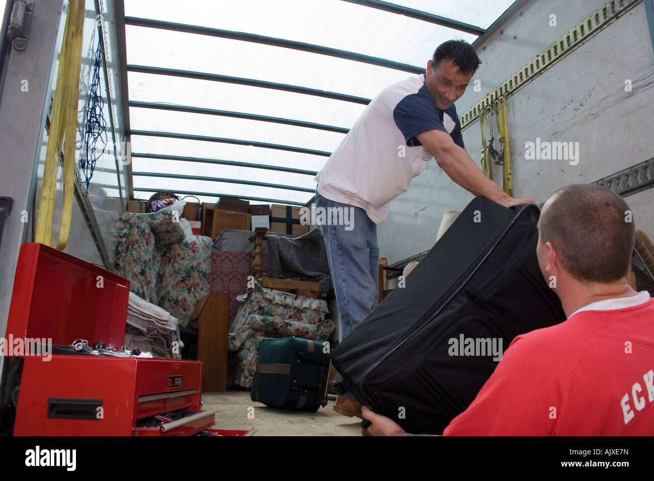 two removal men loading van with household contents Stock Photo