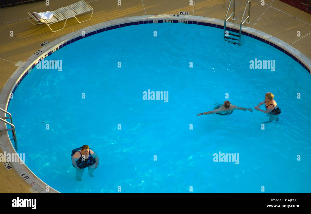 Three people in a swimming pool Stock Photo